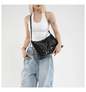Vue détaillée du sac en cuir verni noir avec clous et boucles argentés sur le mannequin