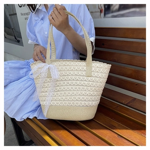 Detail of beige lace woven tote bag featuring layered ruffles and a decorative bow handle