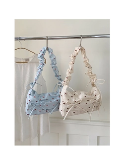 Détail de sacs à main bleus et beiges avec nœuds décoratifs et bandoulières plissées