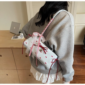 Close-up of white bow shoulder bag with red polka dots and delicate lace trim