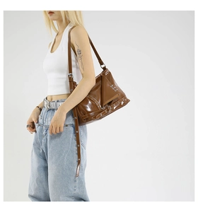 Dettaglio borsa biker in pelle marrone scuro lucida con borchie e fibbie argentate