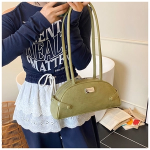 Detail view of olive green crocodile pattern bag with long double straps and silver metal plate