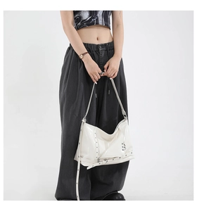 Détail du sac punk blanc avec clous argentés et anneaux métalliques décoratifs