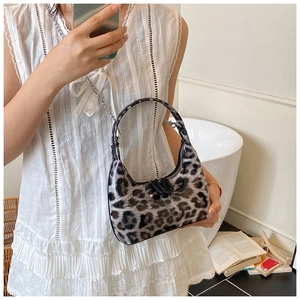 Detail of trendy leopard print dumpling bag with glossy finish and metal chain strap