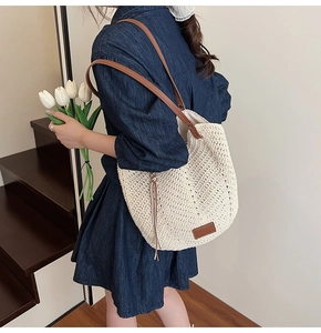 Detail of woven tote bag with brown leather straps and texture on a denim dress