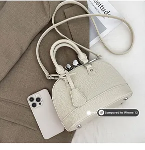 Detailansicht der Mini-Muschel-Tasche mit Metallfüßen und texturiertem Leder-Finish