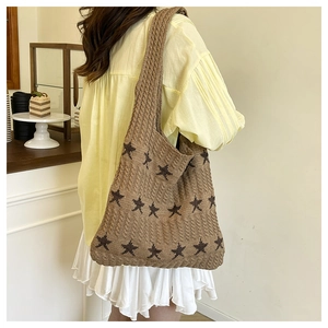 Detail of large woven star tote bag in brown knit fabric with stars pattern
