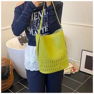 Detail der lindgrünen Beuteltasche mit lasergeschnittenen Mustern und schmalem Schultergurt