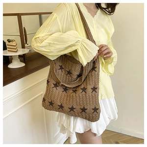Dettaglio ravvicinato della borsa tote in maglia marrone con stelle e trama intrecciata