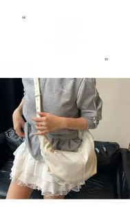 Detail of white corduroy dumpling bag with textured stripes and wide shoulder strap