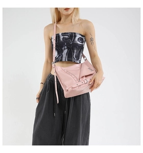 Detail view of pink glossy PU leather tote bag featuring biker jacket elements and hardware