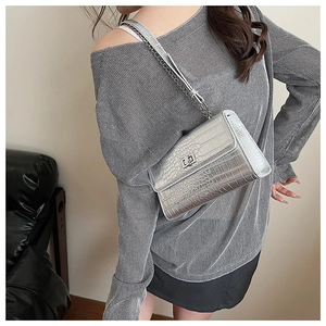 Detail of silver crocodile pattern crossbody bag with metallic chain and rotary lock
