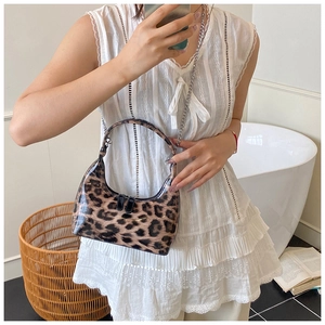 Close-up of leopard print shoulder bag with silver metal chain strap and glossy finish