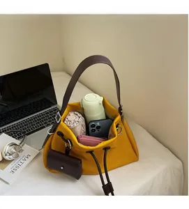 Detailed view of spacious yellow tote bag interior holding phone, bottle, and wallet