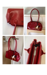 Détails du sac bowling en cuir rouge brillant avec fermeture éclair argentée et bijou