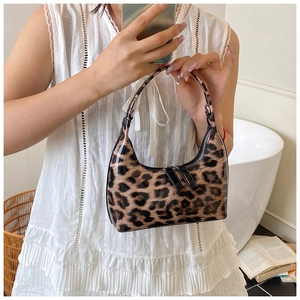 Detail of leopard print shiny patent leather crescent handbag with double metal zippers