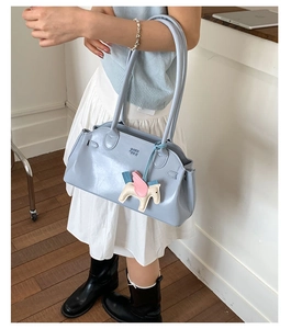 Détail du sac bandoulière bleu clair avec gaufrage SOM SOM et breloque poney en cuir