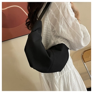 Minimalist black pleated nylon hobo bag shown on model for casual everyday style