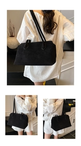 Close-up of black suede tote bag texture with long straps on a white minimalist outfit