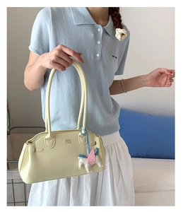 Détail du sac bowling en cuir jaune clair avec breloque Pégase et logo COIN 2DN
