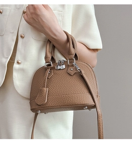 Detail einer braunen Leder-Muscheltasche mit Doppelgriffen und Silberbeschlägen