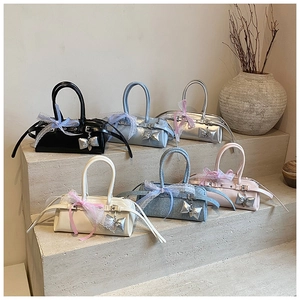 Mini sacs Boston en six couleurs avec nœuds en dentelle sur des marches en pierre