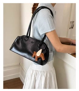 Détail du sac bowling en cuir PU noir brillant avec double bandoulière et charm poney
