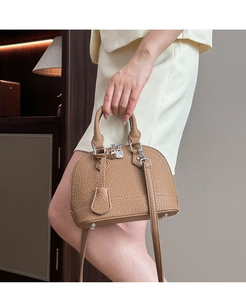 Detailansicht der braunen Shell-Tasche aus genarbtem Leder mit Silber-Beschlägen