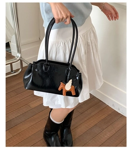Vue détaillée du sac bowling en cuir verni noir avec breloque Pegasus en cuir marron