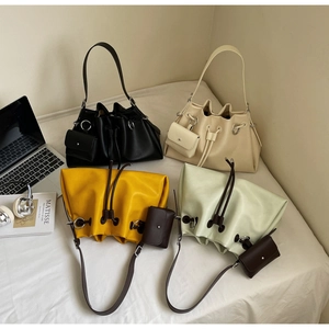 Close-up of drawstring bucket bags in multiple colors with matching mini pouches