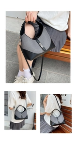 Detail of grey canvas and black leather dumpling bag with silver rotating metal lock buckle