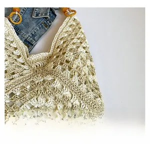 Close-up of beige woven tote bag with openwork texture and amber resin handles