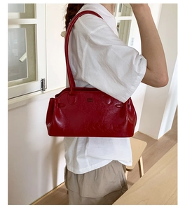 Détail du sac bowling rouge foncé brillant avec longue bandoulière au style rétro