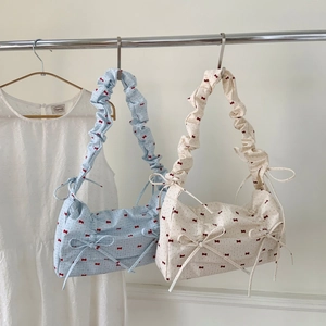Minimalist polka dot hobo bag with red ribbon bow and pleated handle in light blue and white