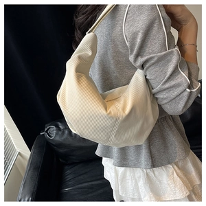 Detailed texture of off-white pleated shoulder bag with integrated wide strap