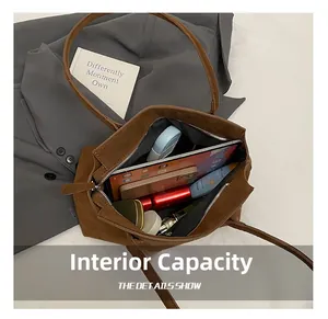 Macro view of spacious interior storage in a brown suede tote bag with daily essentials