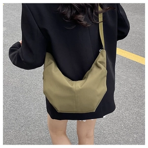 Close-up of olive green corduroy crescent bag showing fabric texture and wide strap