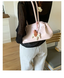 Détail du sac à bandoulière rose brillant avec breloque cheval et logo embossé