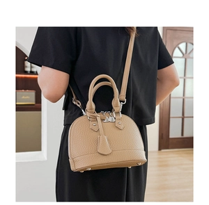Detailansicht der khakifarbenen Muscheltasche mit Lychee-Struktur und Silberbeschlägen