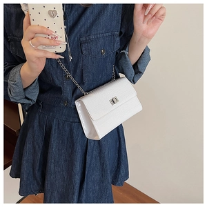 Detail of white crocodile pattern PU leather crossbody bag with silver chain strap and lock
