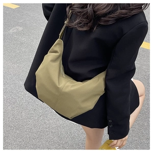 Close-up of khaki hobo bag with vertical ribbed texture and wide shoulder strap