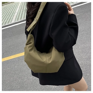 Detail of olive green nylon crescent bag with textured vertical stripes and adjustable strap