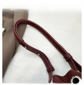Detail of burgundy lychee grain leather strap with silver rivets and metal buckle