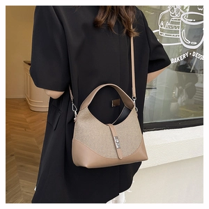 Détail du sac bicolore avec boucle métallique et garniture en cuir sur le côté