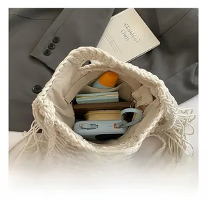 Spacious interior of beige knit crossbody bag with tassels and functional storage pockets