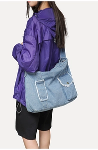 Vue détaillée d'un grand sac cabas en jean bleu clair avec bords effilochés et style urbain