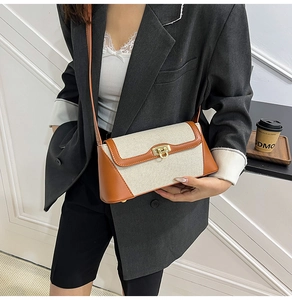Detail showing the brown leather and white canvas patchwork with golden metal buckle clasp