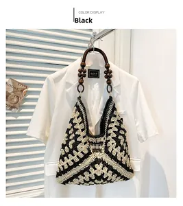 Close-up of handmade woven tote bag with black and white patterns and wooden bead handles