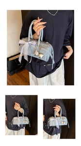 Détail d'un sac à main bleu clair texturé avec nœud en dentelle blanche et pendentif
