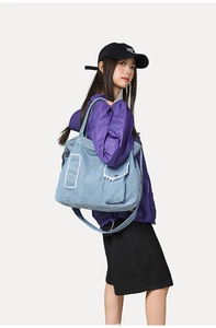 Détail du sac cabas en denim bleu clair avec multi-poches et bords effilochés